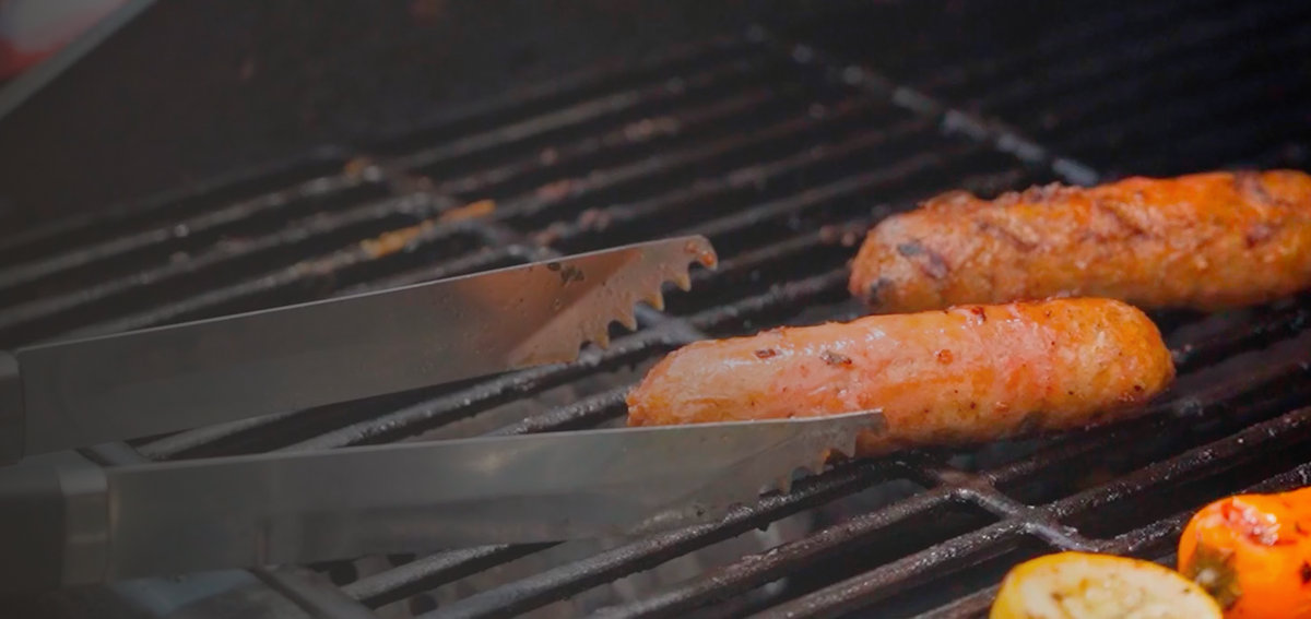 Italian sausages cooking on a grill