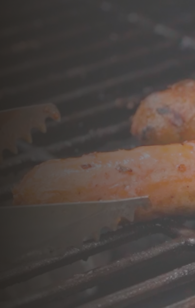 Italian sausages cooking on a grill